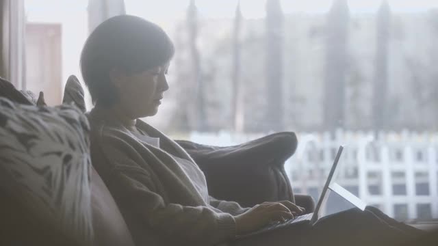 亚洲女性在家里使用笔记本电脑视频下载