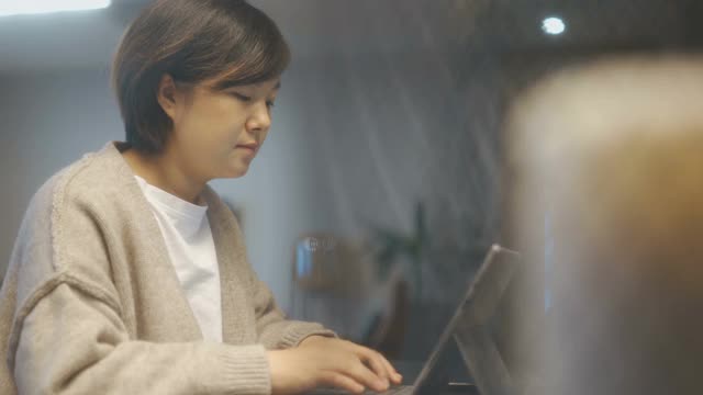 亚洲女性在家里使用笔记本电脑视频素材