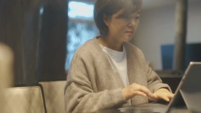 亚洲女性在家里使用笔记本电脑视频下载