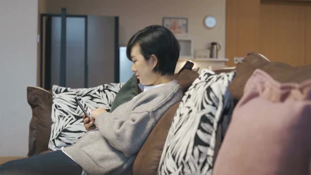 亚洲女性在家里使用智能手机视频素材
