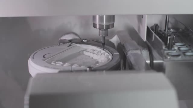 一个专业的数控机器自动创建一个牙齿修复。钻头磨制的是仿陶瓷颌。牙科的先进技术。牙科植体生产视频素材