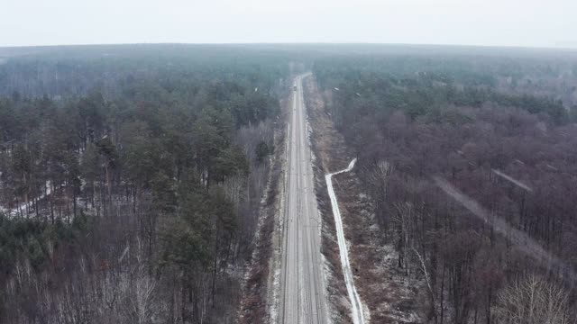 鸟瞰图货运列车旅行在冬天的森林降雪。视频素材