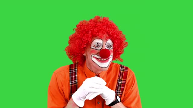 快乐的小丑有一个主意，手指指向绿色屏幕，色度键视频素材