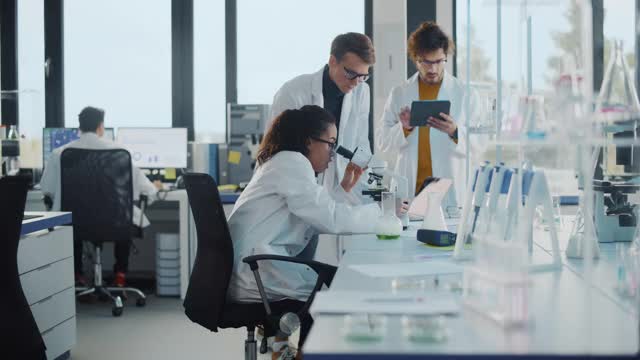 医学实验室:美丽的黑人科学家在显微镜下观察，发现新的药物化合物，与同事击掌和庆祝。年轻的专家，做创新研究视频素材