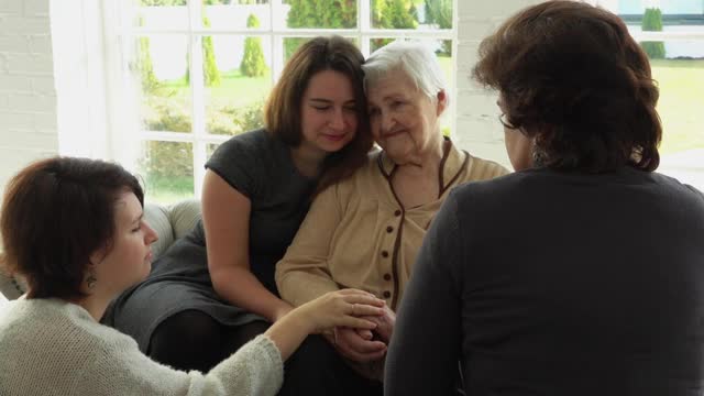 一位白发苍苍的老妇人和她的女儿、孙女坐在一起视频素材