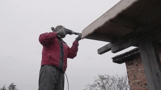 DIY。家居装饰。修理谷仓的屋顶。在COVID-19大流行期间在家工作的活跃的老年人。视频下载