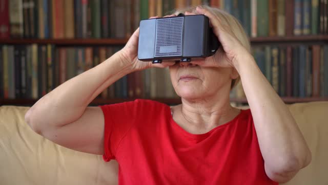 年长的女性在禁闭期间在家使用VR 360眼镜。活跃的现代老年人。视频素材