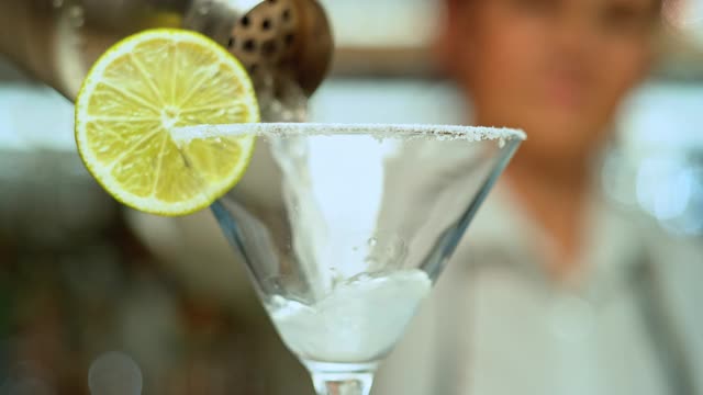 SLO MO LD鸡尾酒从摇酒器倒入v形玻璃杯视频素材