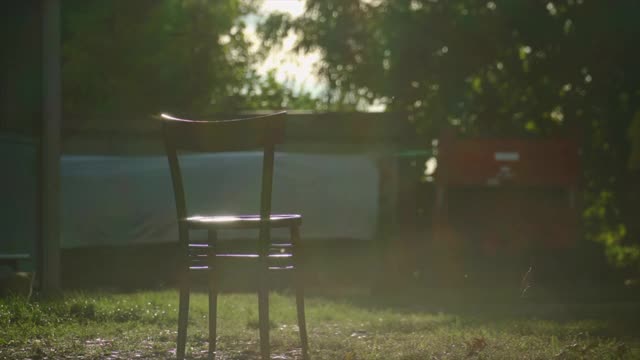 在一个有风的日子日落时，农场里的一把椅子视频下载