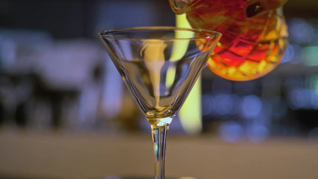 SLO MO DS Barman斟满一个v形鸡尾酒杯与甜的烈酒视频素材