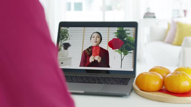 观点自拍视频通话的美丽迷人的年轻亚洲女士在红色春节庆祝服装快乐的微笑交谈和看相机手机祝农历节日。视频素材