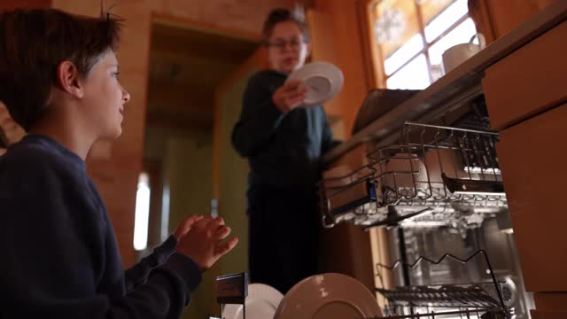 小男孩在往洗碗机里装东西视频下载