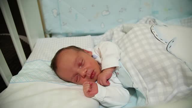 刚出生的婴儿睡在他的婴儿床里视频素材