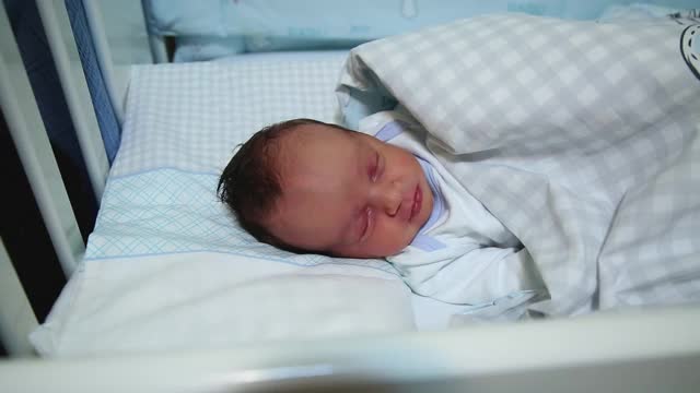 刚出生的婴儿睡在他的婴儿床里视频素材
