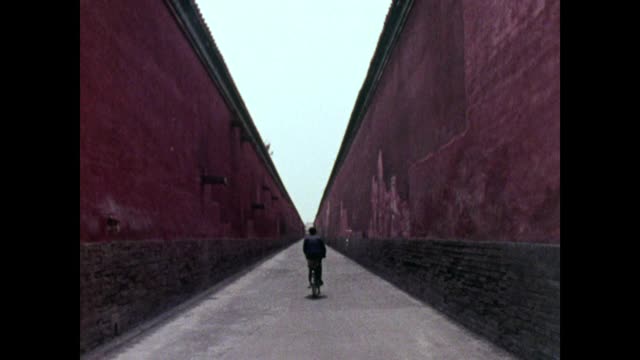 骑自行车的人在红色的墙壁之间急转弯;1973视频素材