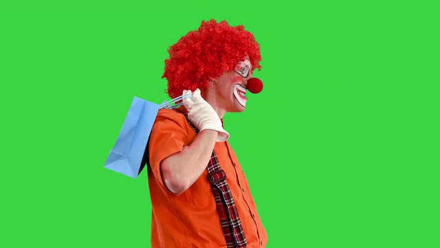 有趣的小丑在一个绿色屏幕购物袋，色度键视频素材