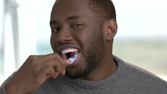 近距离观察一位正在刷牙的美国黑人。视频下载