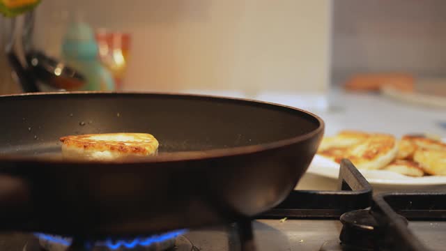 炸油条在煤气炉上的煎锅里炸着，背景是餐桌视频下载