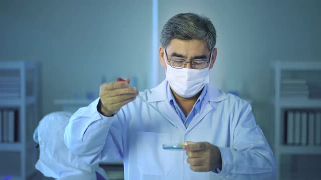科学家在实验室里拿着液体化学管，科技保健理念视频素材