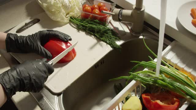 在水槽边的木板上切甜椒和新鲜蔬菜视频下载