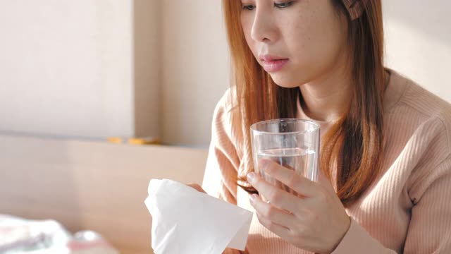 一个女人得了流感，用纸巾打喷嚏视频素材