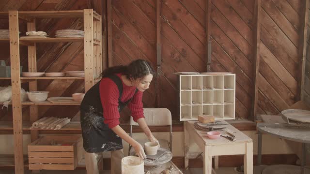 在陶艺工作室工作的年轻女子视频素材