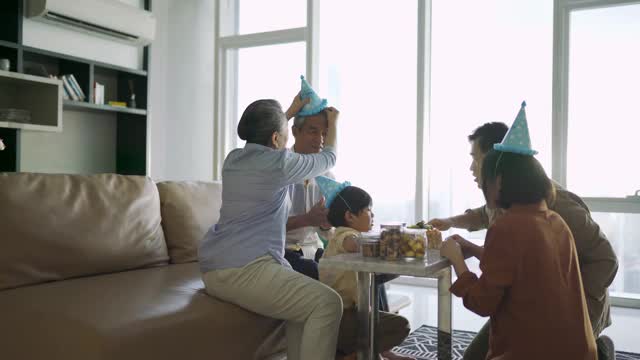 亚洲华人父母和祖父母一起为儿子唱生日歌视频素材