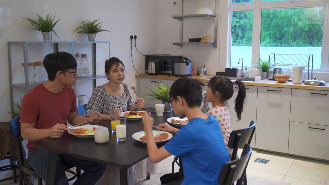 亚洲华人父母与孩子在厨房吃早餐视频下载