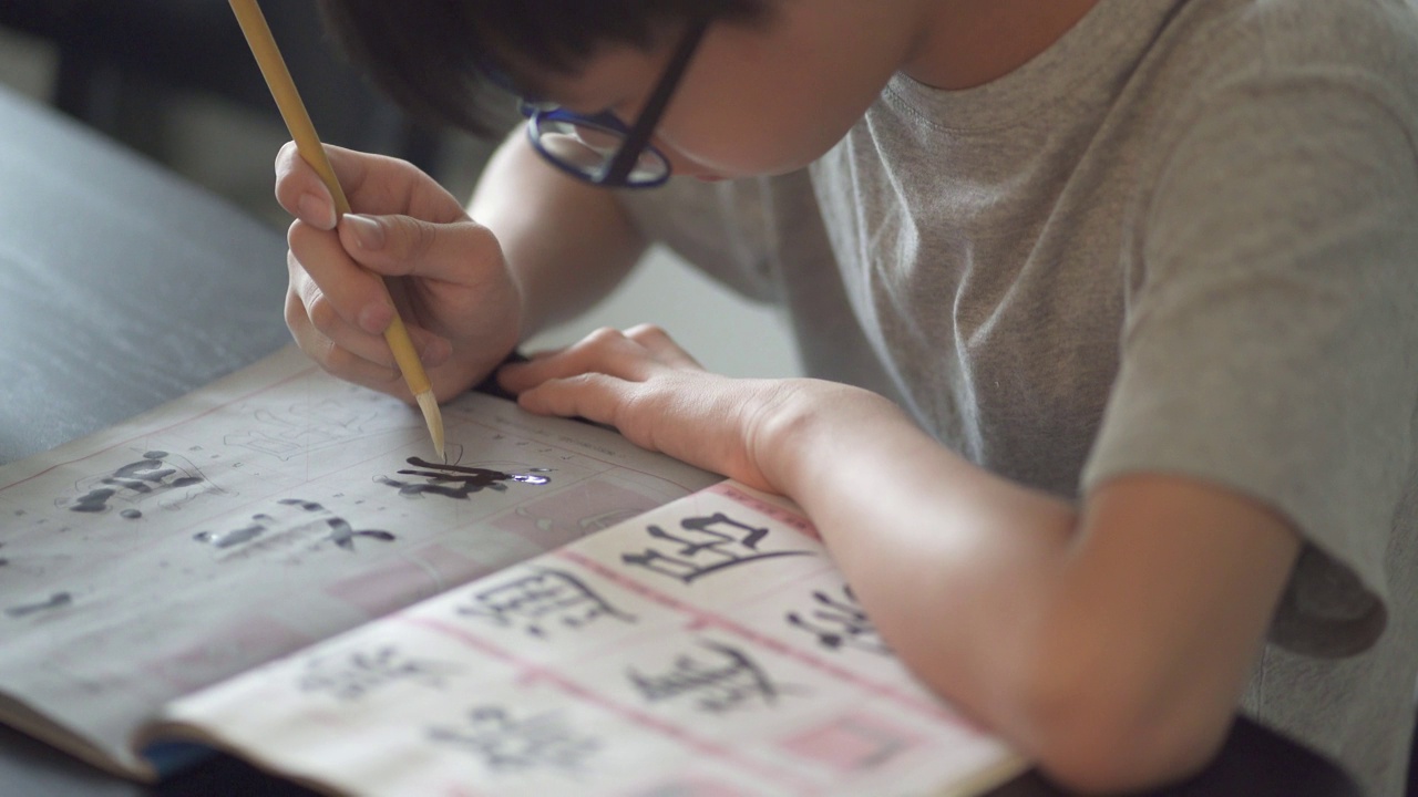 亚洲中国少年在家里练习中国书法视频素材