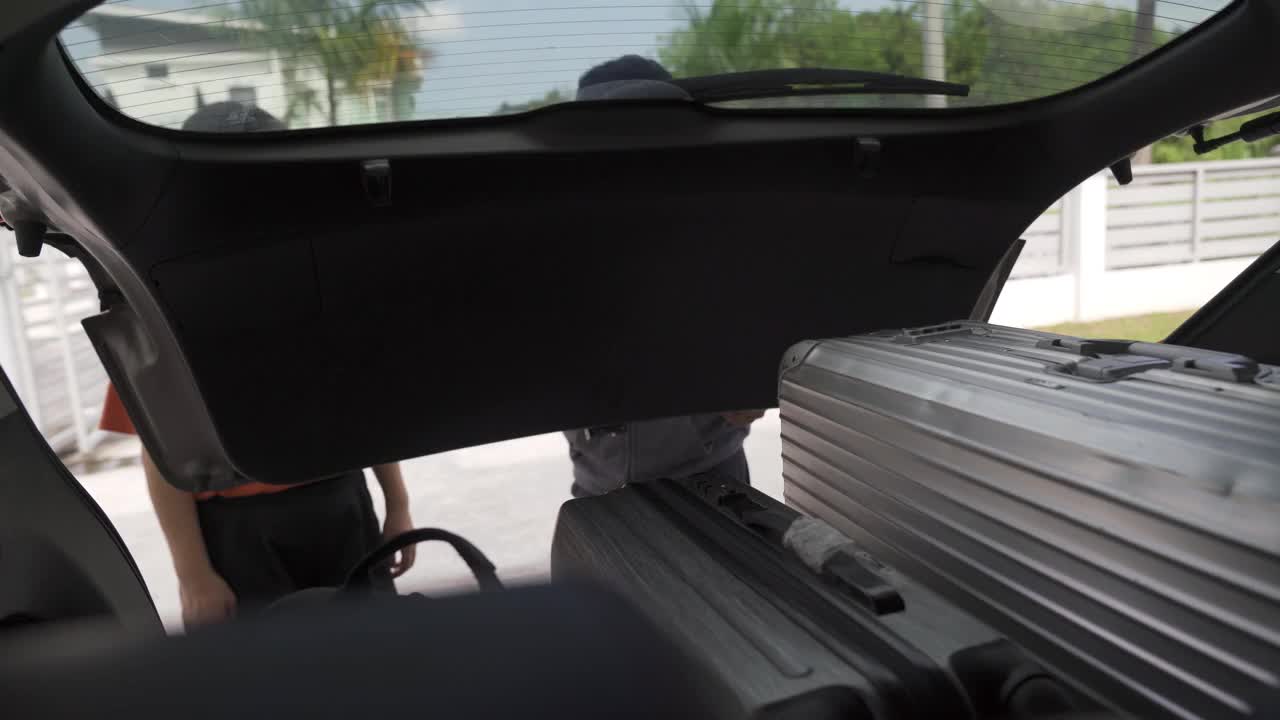 一对亚洲中国夫妇从他们的车里卸下行李视频素材