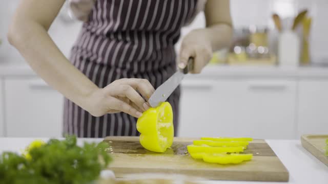 用刀切黄甜椒的女人视频素材