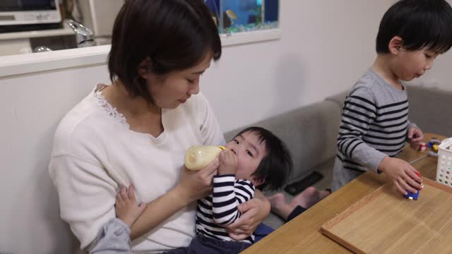 年轻的母亲在家里给她的男婴喂奶视频素材