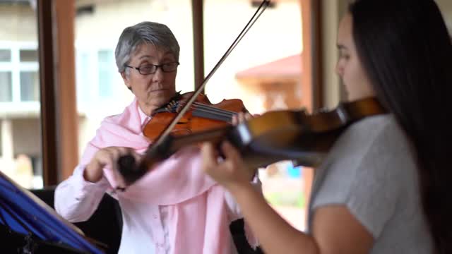 高级小提琴老师教一个女孩拉小提琴视频素材