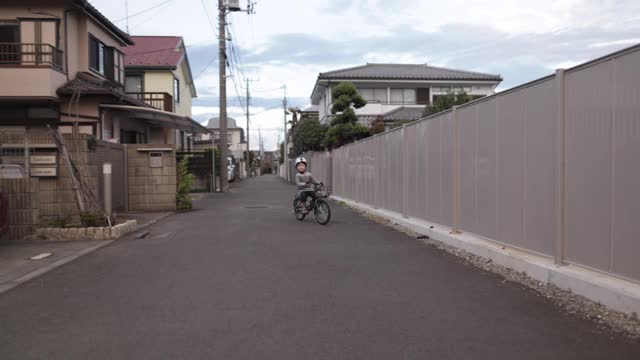 小男孩在街上练习骑自行车视频素材