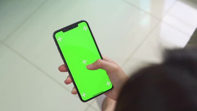特写亚洲女性使用绿色屏幕的智能手机视频下载