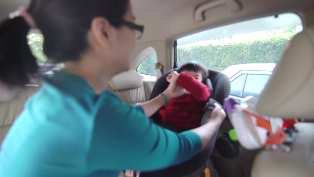亚裔妈妈带着她的儿子坐在汽车座椅上视频下载
