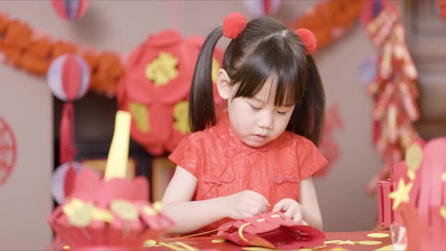 年轻的女孩在家里制作传统的中国新年工艺品来庆祝视频素材