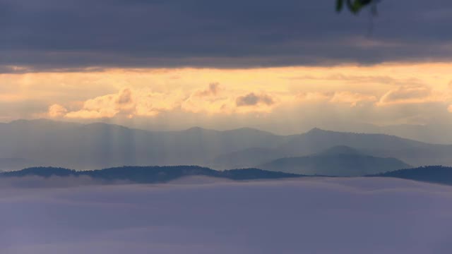 间隔拍摄。4 k。早晨日出时，山上有阳光和雾。视频素材