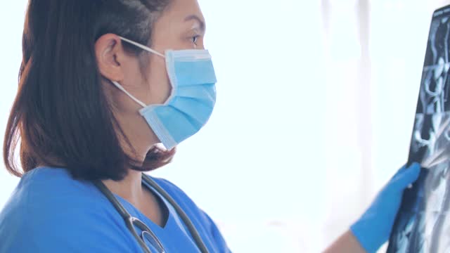 女医生分析x光片在她的工作空间在医院视频下载