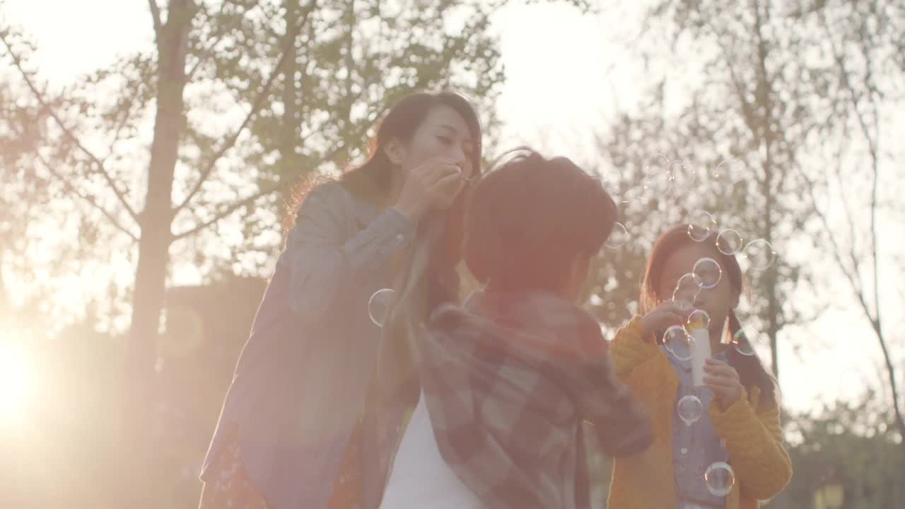 幸福的年轻家庭在公园吹泡泡，4K视频下载