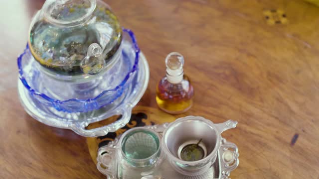 女子将茶从玻璃壶倒入杯中，茶道概念视频素材