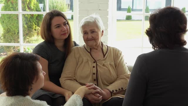一位白发苍苍的老妇人和她的女儿、孙女们坐在一起视频素材