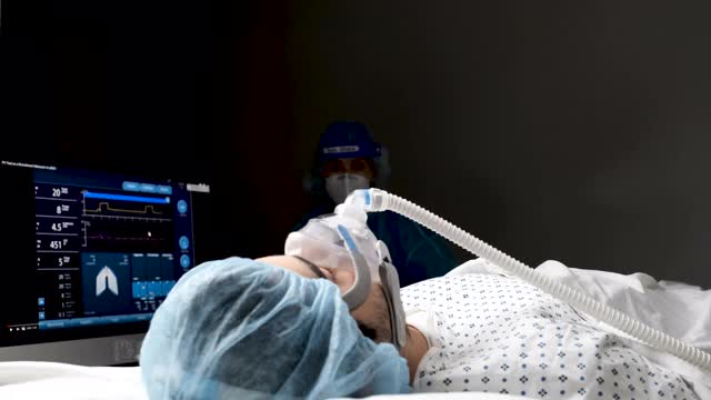 连接呼吸机的年轻男子正在接受医护人员的检查视频素材