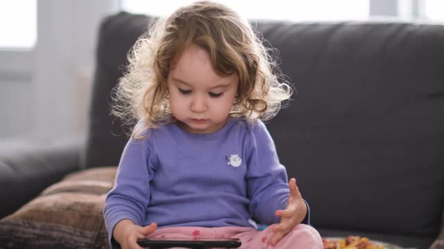 可爱的小女孩在玩智能手机视频素材