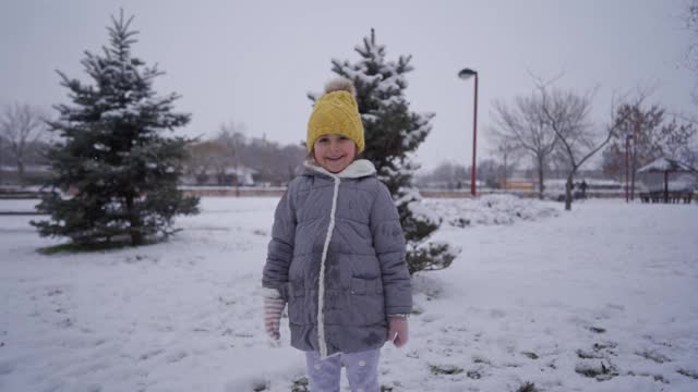 可爱的微笑女孩享受第一天的雪视频素材