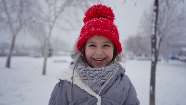 一个可爱的女孩在享受雪天的时候无法掩饰她的兴奋视频素材