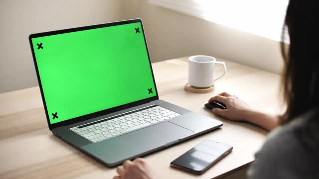 在家里使用绿屏笔记本电脑的妇女视频素材