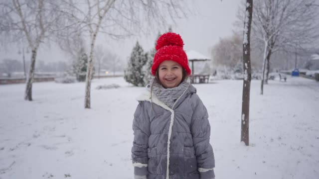 可爱的微笑女孩享受寒冷的雪天视频素材