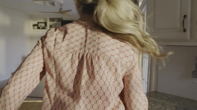 在美国犹他州高地的沙发上，女儿追着调皮的母亲搔痒的慢动作视频素材