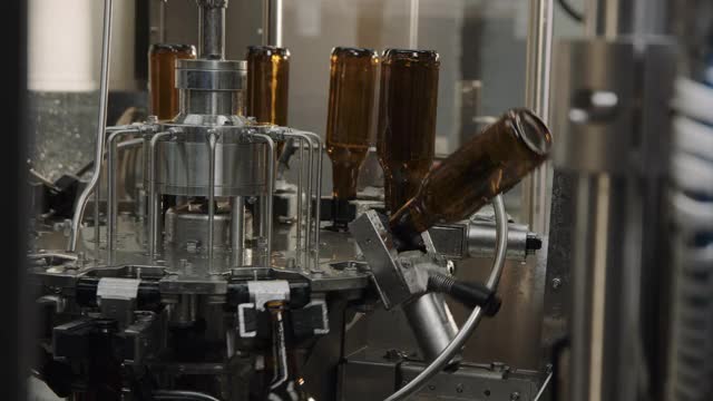 啤酒厂自动机器上的瓶子视频素材